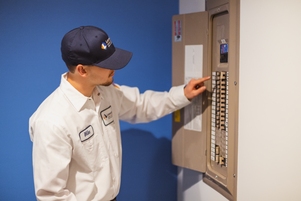 Lancaster Plumbing, Heating, Cooling & Electrical technician inspects a breaker box