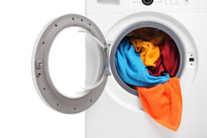Close up of a washing machine loaded with clothes