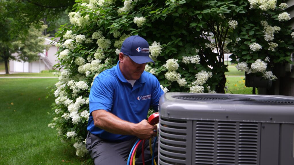 Lancaster Plumbing & Heating employee testing outdoor AC unit.