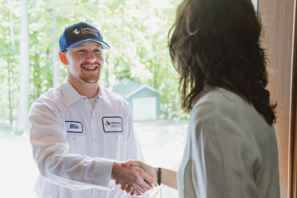 Lancaster Plumbing & Heating employee shakes homeowners hand