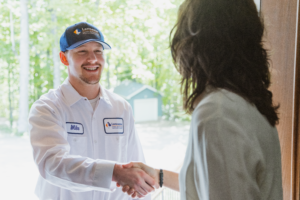 Lancaster Plumbing & Heating employee shakes homeowner's hand at the front door.