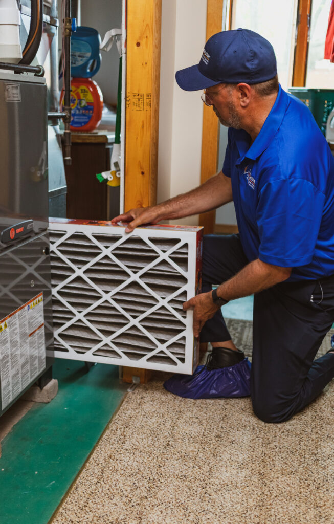 Lancaster HVAC technician replaces an air filter in a home.