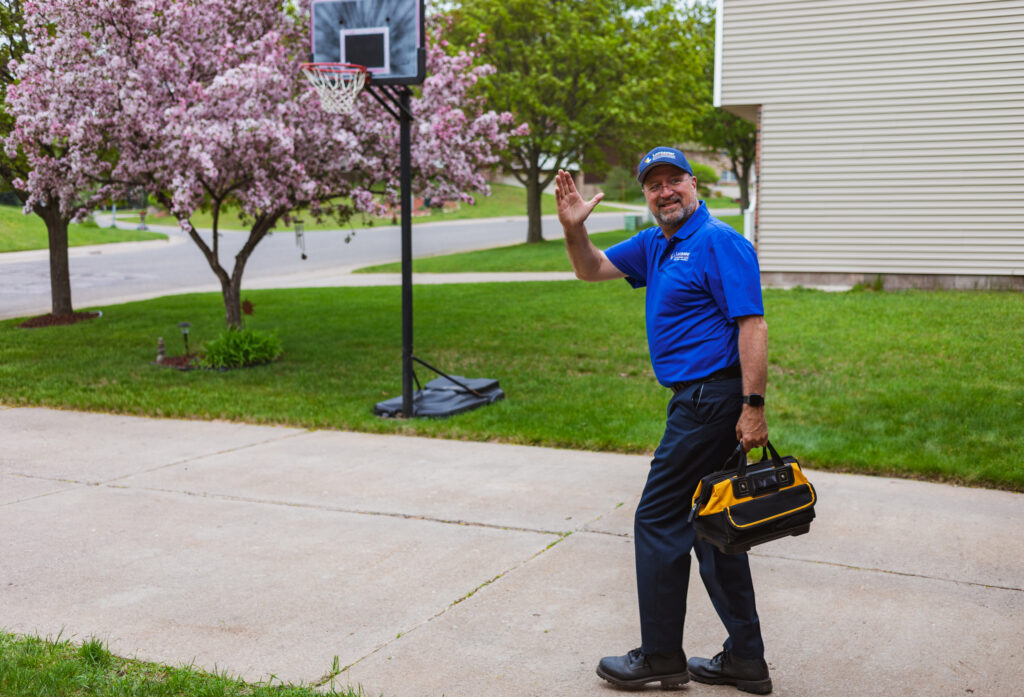 Lancaster employee waving goodbye to homeowner in a residential neighborhood
