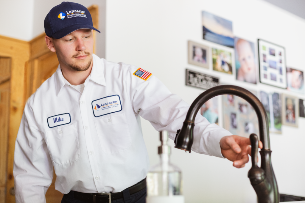 plumber inspecting faucet in a house