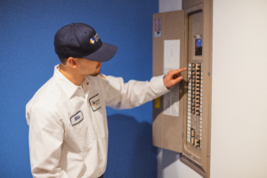 electrician inspects breaker panel