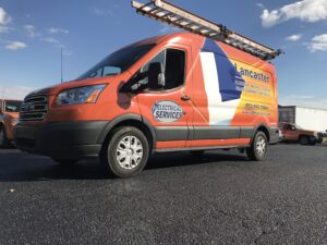 Lancaster Plumbing & Heating service van parked outside.