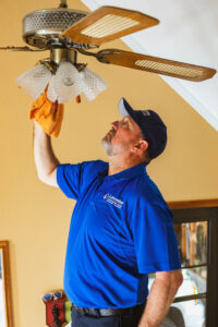 Lancaster electrician inspecting the wiring on an old ceiling fan.