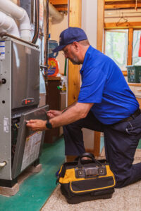 HVAC technician inspects furnace inside a house