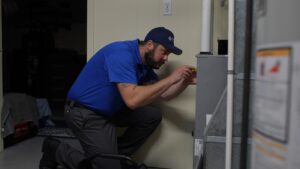 HVAC technician inspects furnace in home