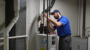 Lancaster plumber inspecting a water heater in a home's basement.
