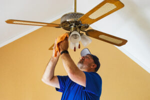Electrician installing ceiling fan lights