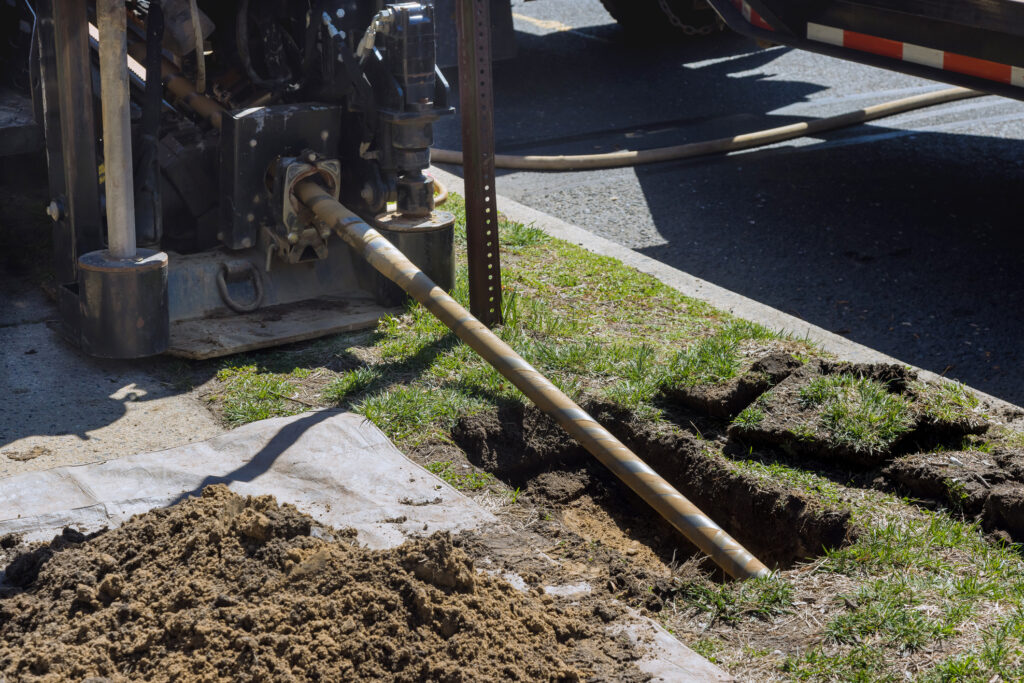 Low-angle view of trenchless laying of communications, fiber optic and water pipes with horizontal directional drilling technology machine work process