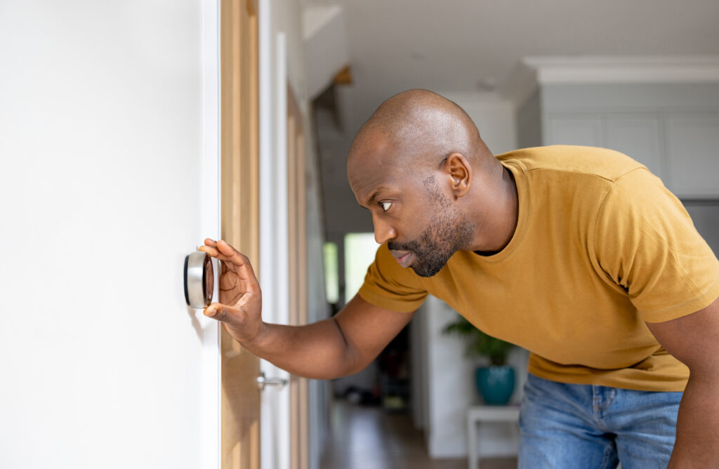 Homeowner adjusting thermostat settings